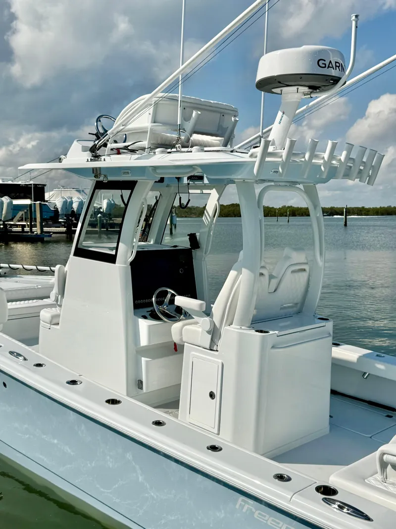 Slide: The Image of Freeman 28 boat, 2025 model, with advanced navigation equipment, docked in a marina. - 7
