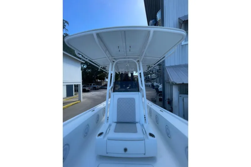 Slide: The Image of 2015 Barker Boatworks 26 Bay with Garmin radar, docked near a metal building. - 11