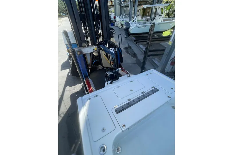 Slide: The Image of 2015 Barker Boatworks 26 Bay on forklift, showcasing deck and outboard motor. - 24