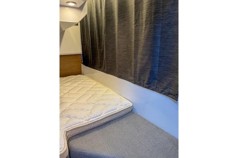 Slide: The Image of 2024 Beneteau Antares 9 cabin interior with bed and curtain. - 11