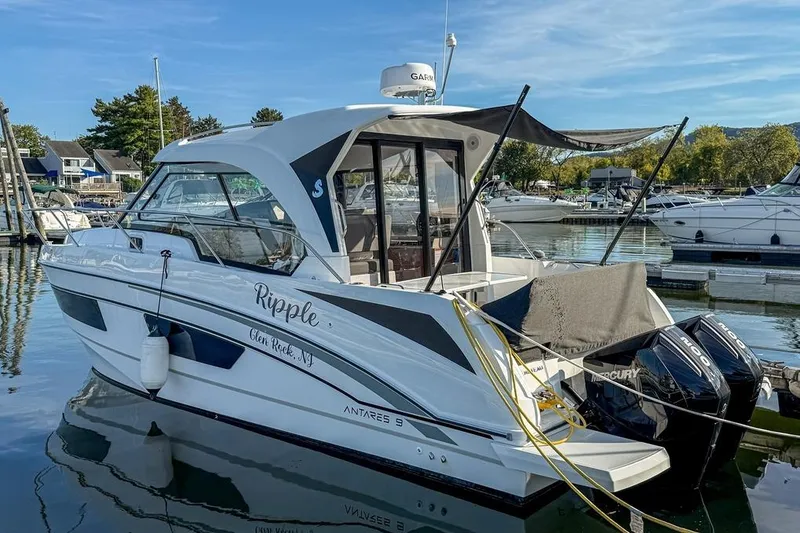 Slide: The Image of 2024 Beneteau Antares 9 boat docked in a marina, featuring twin Mercury engines. - 2