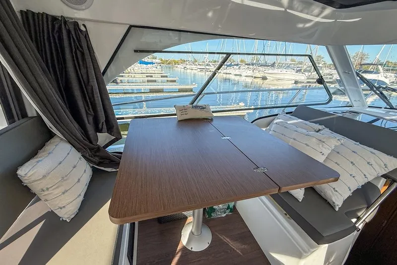 Slide: The Image of Interior of 2024 Beneteau Antares 9 with table and marina view. - 7