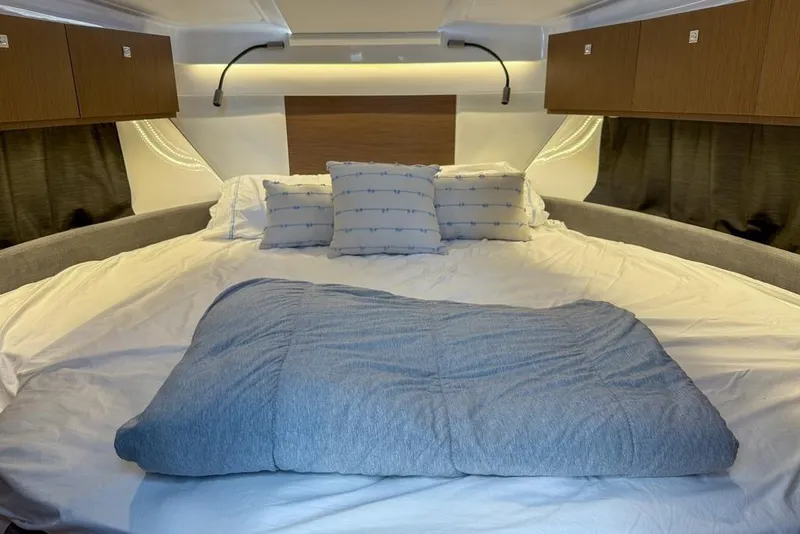 Slide: The Image of Luxurious cabin interior of 2024 Beneteau Antares 9 with cozy bedding and modern lighting. - 9