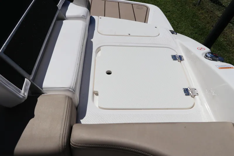 Slide: The Image of 2021 Chaparral 23 SSi OB boat interior with cushioned seating and storage compartment. - 10