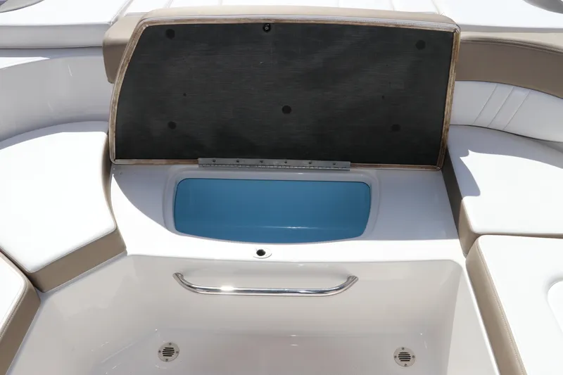 Slide: The Image of 2021 Chaparral 23 SSi OB boat storage compartment with open lid and blue interior. - 17