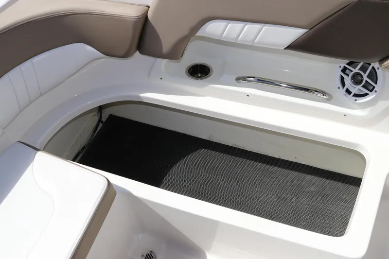 Slide: The Image of 2021 Chaparral 23 SSi OB boat interior seating with storage compartment and speaker. - 23
