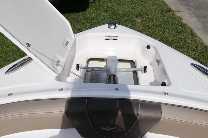 Slide: The Image of 2021 Chaparral 23 SSi OB boat anchor compartment open, showing storage details. - 62