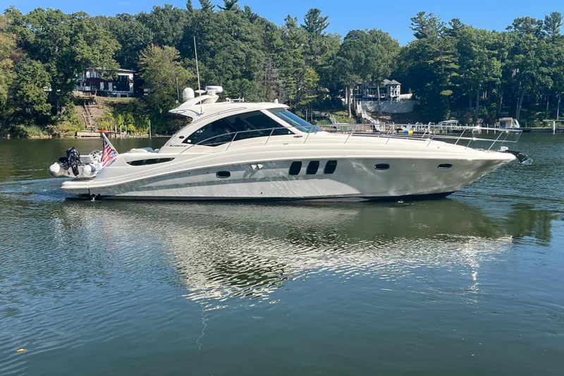 Slide: The Image of 2009 Sea Ray 48 Sundancer yacht on a serene lake with lush green trees. - 3