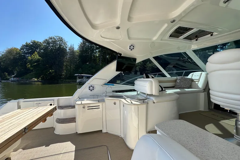 Slide: The Image of Luxurious 2009 Sea Ray 48 Sundancer yacht interior with seating, table, and scenic lake view. - 7
