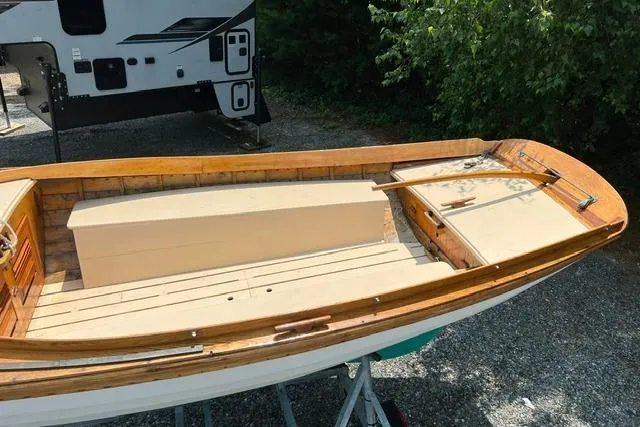Slide: The Image of 1980 Buzzards Bay sloop with wooden deck, parked on gravel near trees and a trailer. - 3