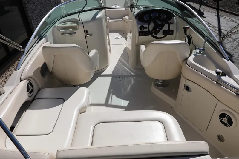 Slide: The Image of 2008 Sea Ray 220 Sundeck interior with beige seating and steering console. - 1