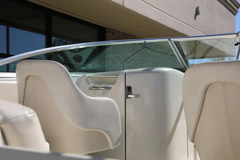 Slide: The Image of 2008 Sea Ray 220 Sundeck interior with white seating and glass windshield. - 11