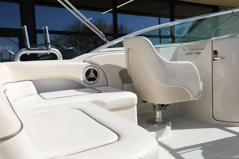 Slide: The Image of Interior of a 2008 Sea Ray 220 Sundeck boat with white seating and steering area. - 2