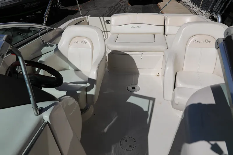 Slide: The Image of 2008 Sea Ray 220 Sundeck interior with white seating and steering wheel. - 23