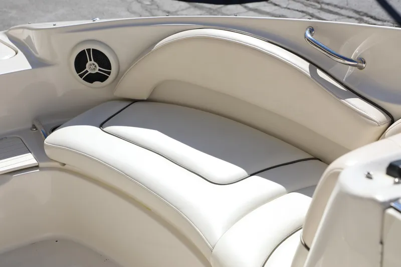 Slide: The Image of 2008 Sea Ray 220 Sundeck interior with white cushioned seating and speaker detail. - 3