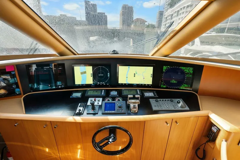 Slide: The Image of 2008 Lazzara Motor Yacht helm with navigation screens and controls, cityscape view through windows. - 24