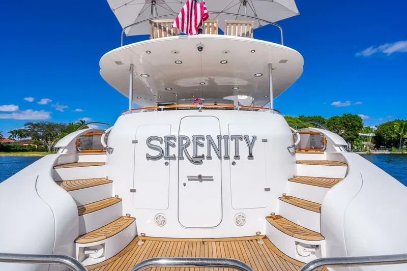 Slide: The Image of 2008 Lazzara Motor Yacht "Serenity" with elegant design and wooden steps, docked under clear skies. - 58
