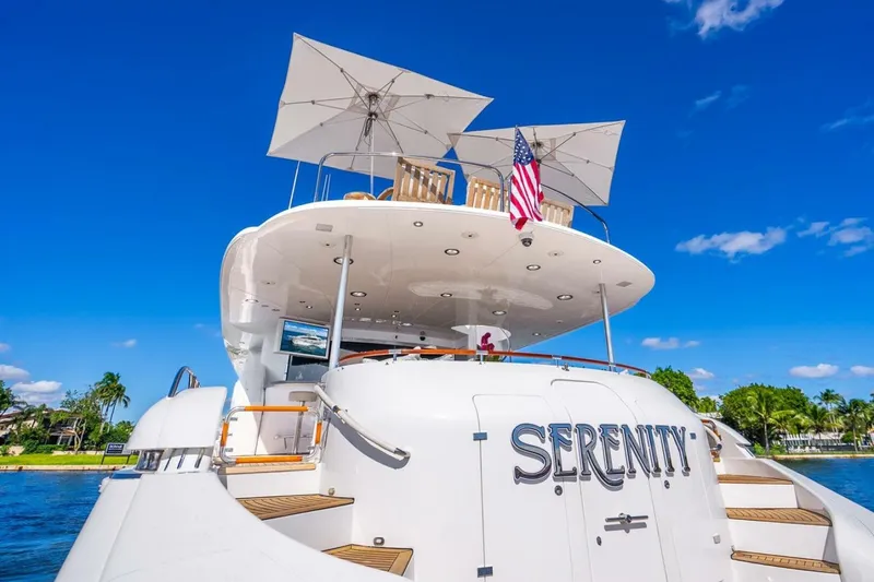 Slide: The Image of 2008 Lazzara Motor Yacht "Serenity" with American flag, docked under clear blue sky. - 59