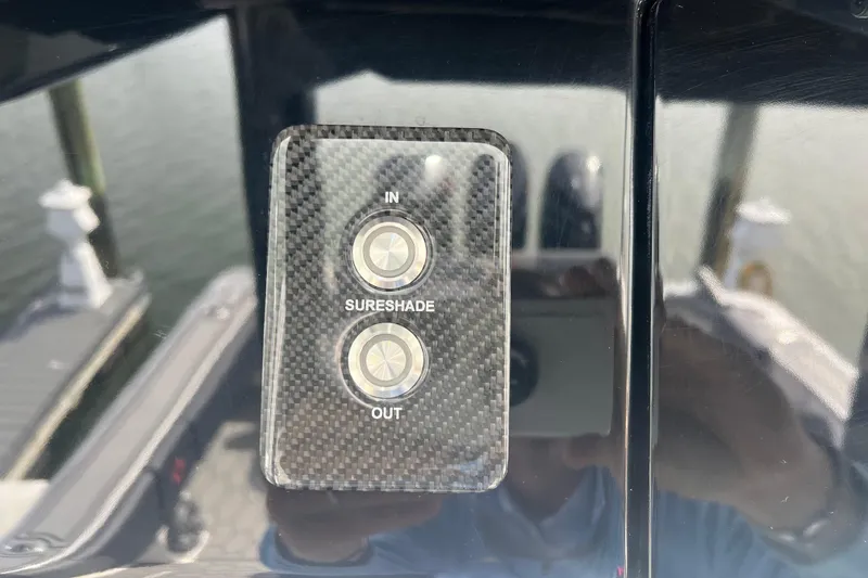 Slide: The Image of Control panel for SureShade on 2021 Fountain 39 NX boat, featuring "In" and "Out" buttons. - 16