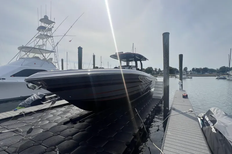 Slide: The Image of 2021 Fountain 39 NX boat docked at marina under bright sunlight. - 6
