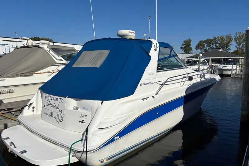 The Image of 1995 Sea Ray 330 Sundancer docked, featuring blue cover and sleek design. - 0