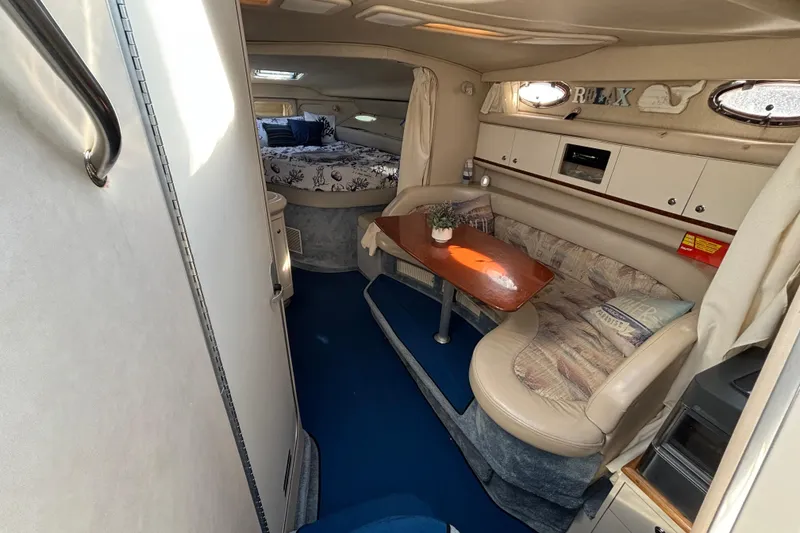Slide: The Image of Interior of 1995 Sea Ray 330 Sundancer with cozy seating and dining area. - 11