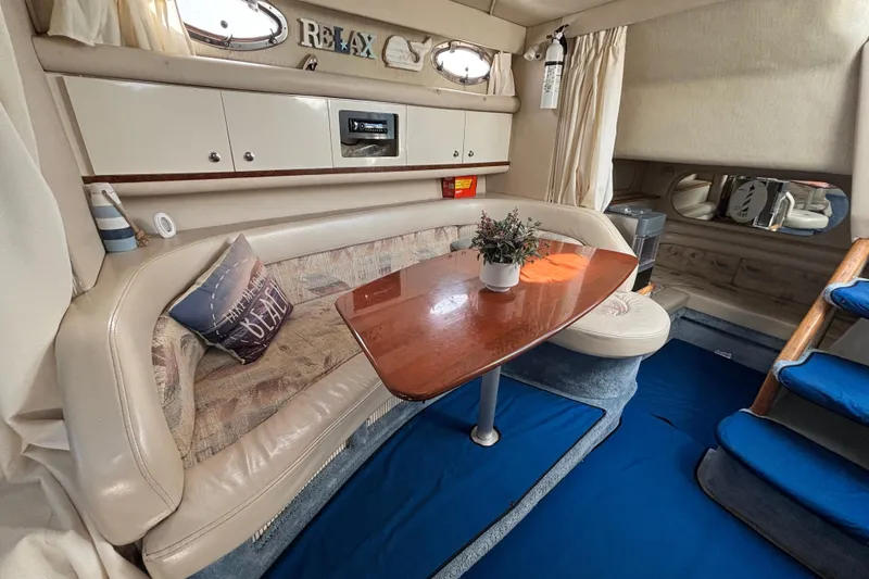 Slide: The Image of 1995 Sea Ray 330 Sundancer cabin interior with cozy seating and wooden table. - 12