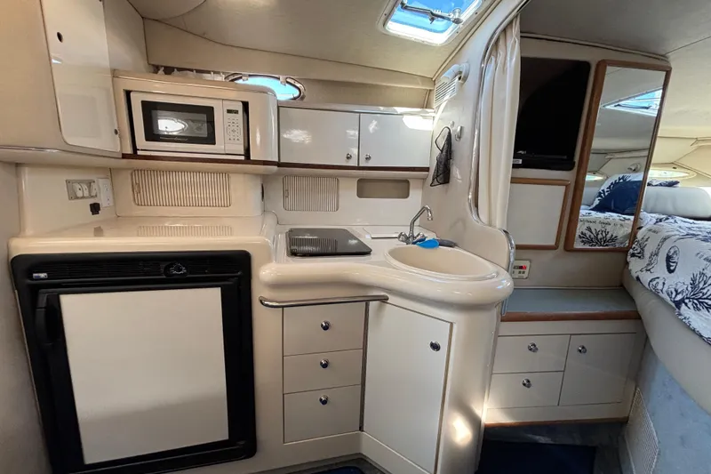 Slide: The Image of Interior of 1995 Sea Ray 330 Sundancer with kitchenette, microwave, and cozy sleeping area. - 13