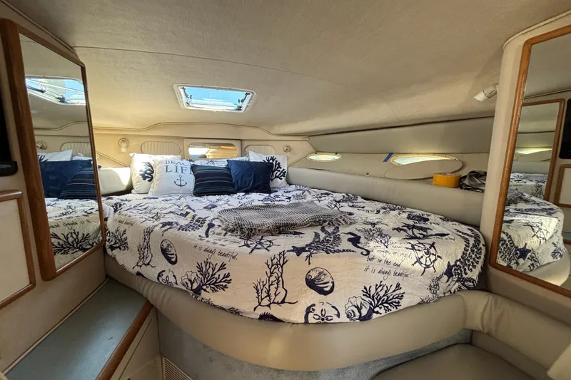Slide: The Image of Cozy cabin interior of 1995 Sea Ray 330 Sundancer with nautical-themed bedding. - 14