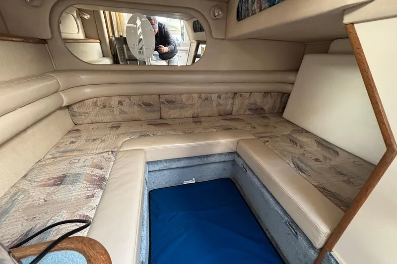 Slide: The Image of 1995 Sea Ray 330 Sundancer cabin interior with beige seating and storage compartment. - 15