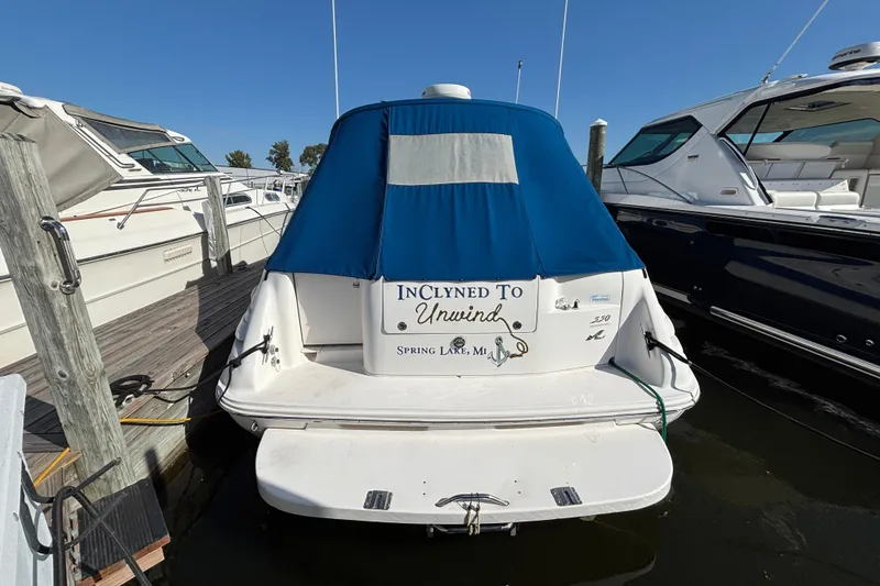 Slide: The Image of 1995 Sea Ray 330 Sundancer docked, covered, with "Inclined to Unwind" nameplate. - 2