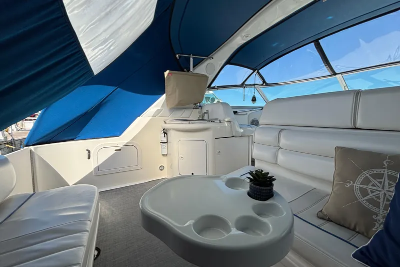 Slide: The Image of Interior of 1995 Sea Ray 330 Sundancer with white seating and blue canopy. - 5