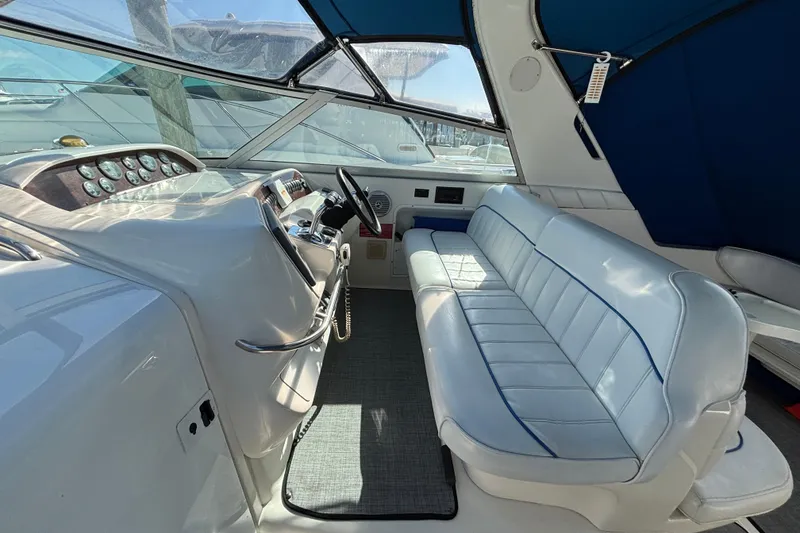Slide: The Image of 1995 Sea Ray 330 Sundancer cockpit with white seating and dashboard controls. - 7