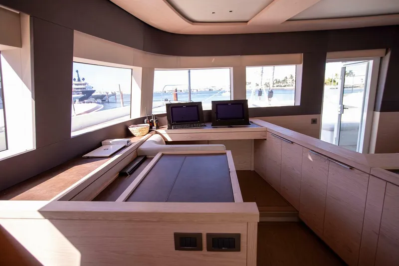 Slide: The Image of Interior of 2021 Lagoon Seventy 7 yacht with modern navigation station and panoramic windows. - 18