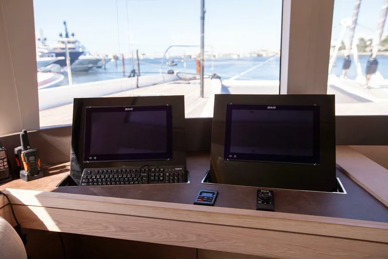 Slide: The Image of Control panel of 2021 Lagoon Seventy 7 yacht with dual screens and keyboard. - 19