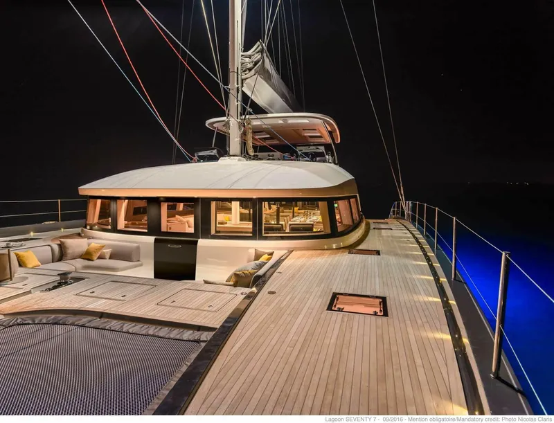 Slide: The Image of 2021 Lagoon Seventy 7 yacht at night, featuring elegant deck and illuminated interior. - 2