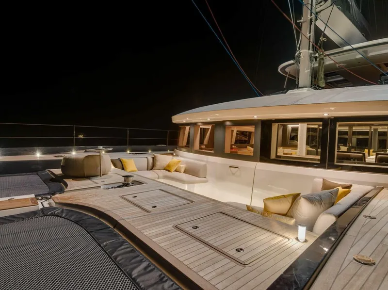 Slide: The Image of Luxurious 2021 Lagoon Seventy 7 yacht deck at night, featuring elegant seating and ambient lighting. - 3