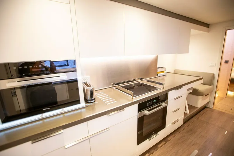 Slide: The Image of Modern kitchen interior in 2021 Lagoon Seventy 7 yacht with sleek appliances and seating area. - 34