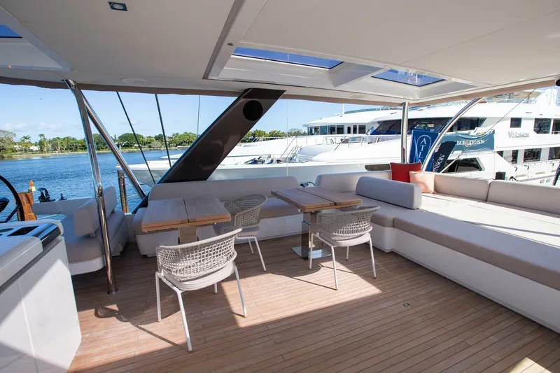 Slide: The Image of Spacious deck of 2021 Lagoon Seventy 7 yacht with seating and tables, docked by the water. - 44