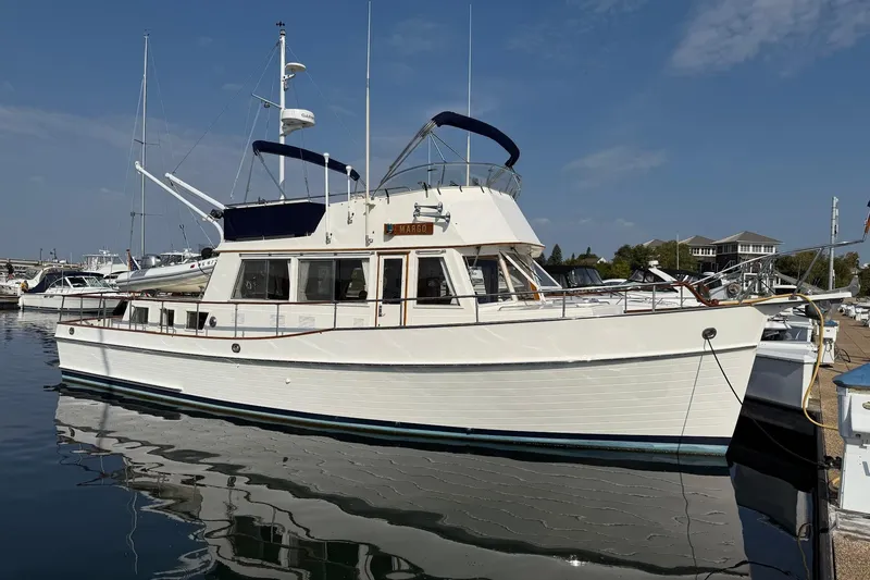 The Image of 1996 Grand Banks 42 Classic yacht docked at marina under clear blue sky. - 0