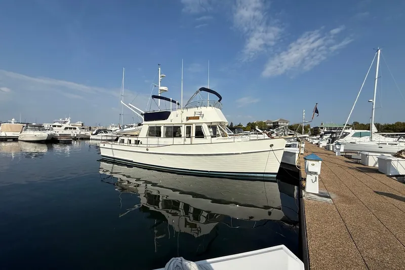 Slide: The Image of Flybridge of 1996 Grand Banks 42 Classic yacht with seating and table, docked at marina. - 1