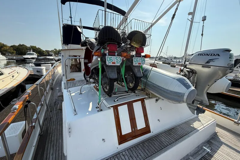 Slide: The Image of 1996 Grand Banks 42 Classic yacht helm with wooden wheel and seating at marina. - 17