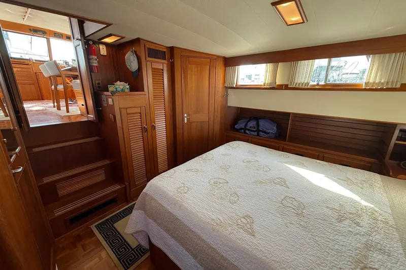 Slide: The Image of Cozy bedroom in a 1996 Grand Banks 42 Classic yacht with wood accents and natural light. - 34