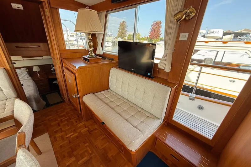 Slide: The Image of Interior of 1996 Grand Banks 42 Classic yacht with wooden helm and cozy seating area. - 45