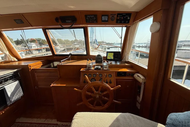 Slide: The Image of Helm of 1996 Grand Banks 42 Classic yacht with wooden steering wheel and plush seating. - 48