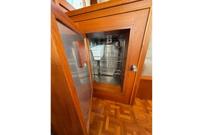 Slide: The Image of Wooden cabinet with open door revealing interior shelves on a 1996 Grand Banks 42 Classic. - 59