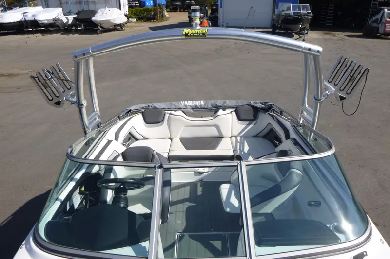 Slide: The Image of 2015 Yamaha Boats SX192 with sleek interior and wakeboard tower in a marina setting. - 20