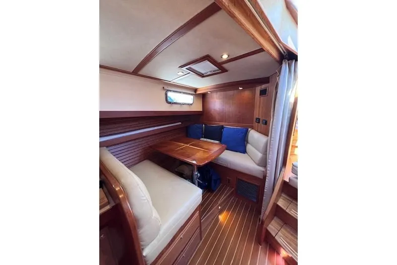 Slide: The Image of 2012 Sabre 42 Salon Express interior with wooden dining area and cushioned seating. - 17