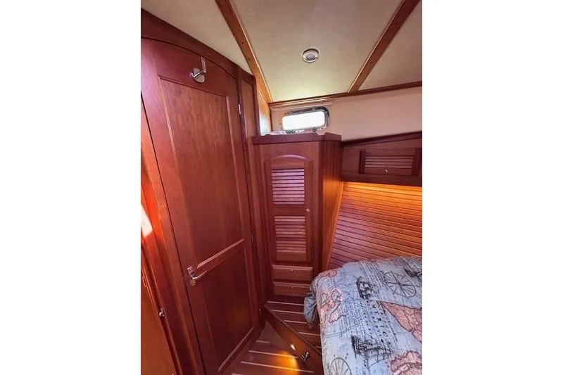 Slide: The Image of Interior cabin of 2012 Sabre 42 Salon Express with wooden finishes and nautical-themed bedding. - 22