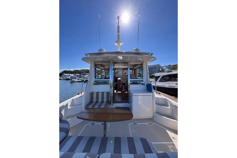 Slide: The Image of 2012 Sabre 42 Salon Express yacht with sunlit deck and striped seating. - 3